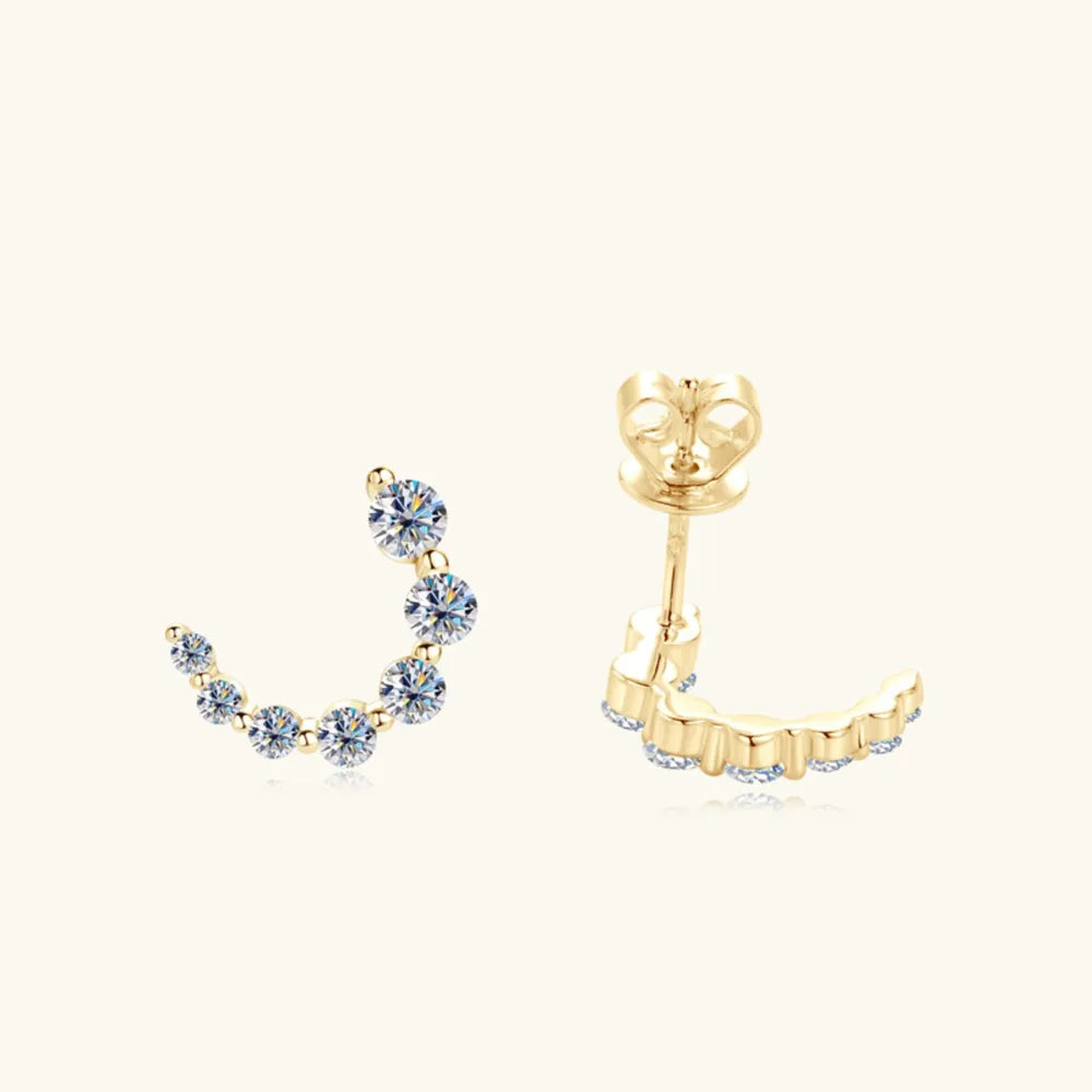 Gold Celestial Arc Moissanite Earrings with sparkling stones in a curved design.