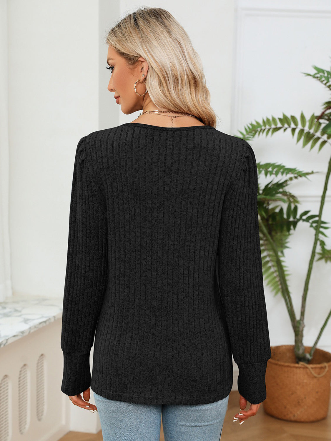 Black ribbed knit sweater with crochet trim detail, long sleeves, and crew neck.