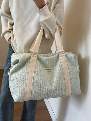 Light blue textured travel bag with cream straps and a detachable pouch.
