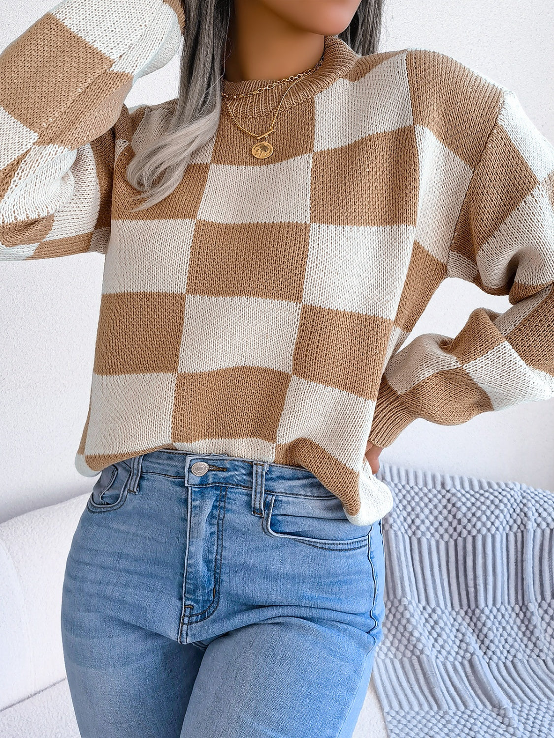 Checkerboard knit mock neck pullover sweater in camel and white acrylic with long sleeves.