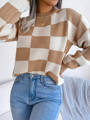 Checkerboard knit mock neck pullover sweater in camel and white acrylic with long sleeves.