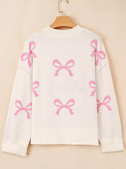 Beige drop shoulder sweater with allover pink bow print, acrylic blend.