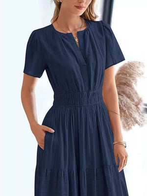 Dark blue ruched V-neck tiered midi dress with short sleeves and elastic waist.