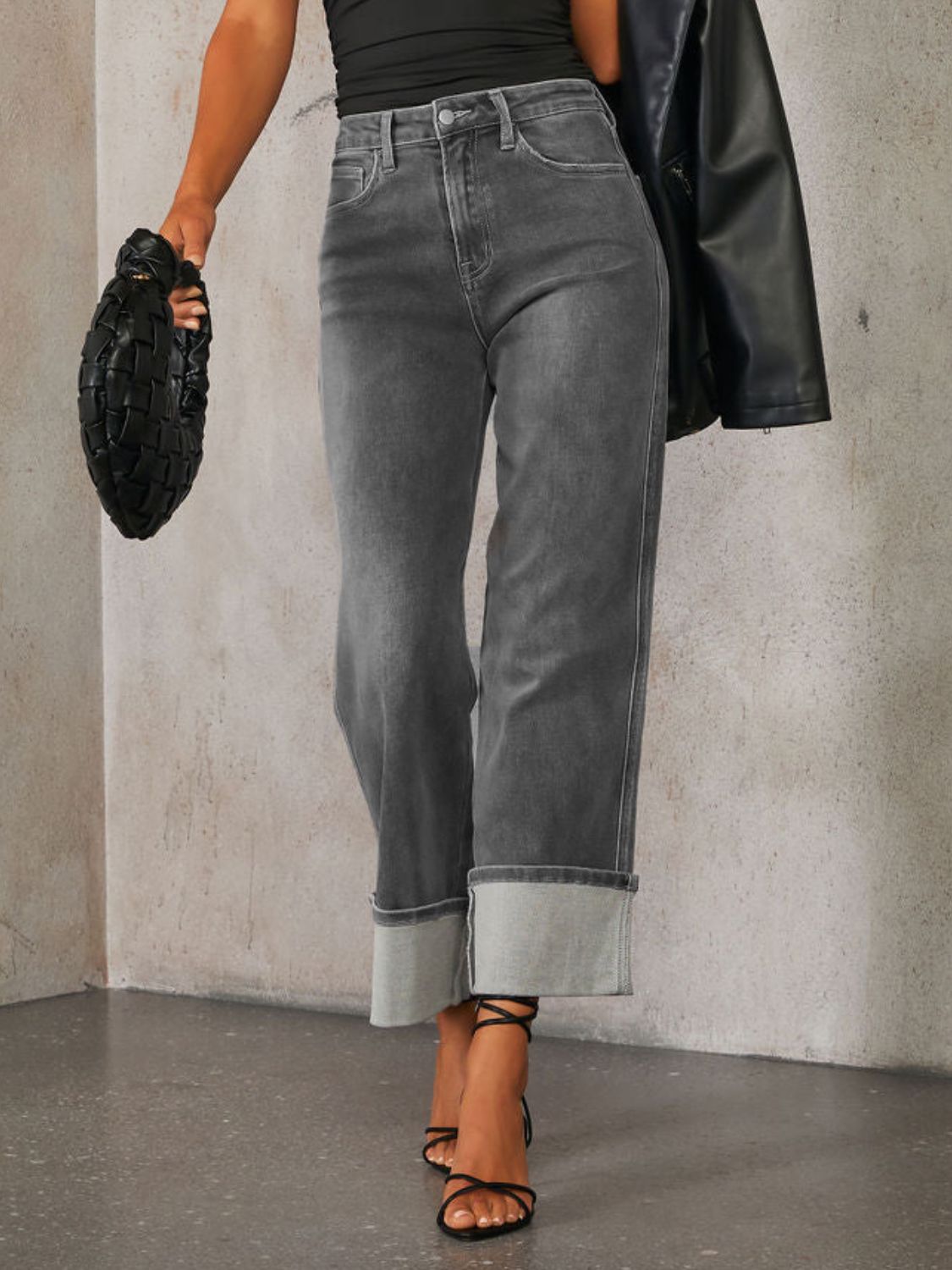 Dark wash denim jeans with cuffed hems and a wide-leg cut.