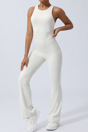 White cross-back flare leg unitard with ruched sides and a racerback detail.
