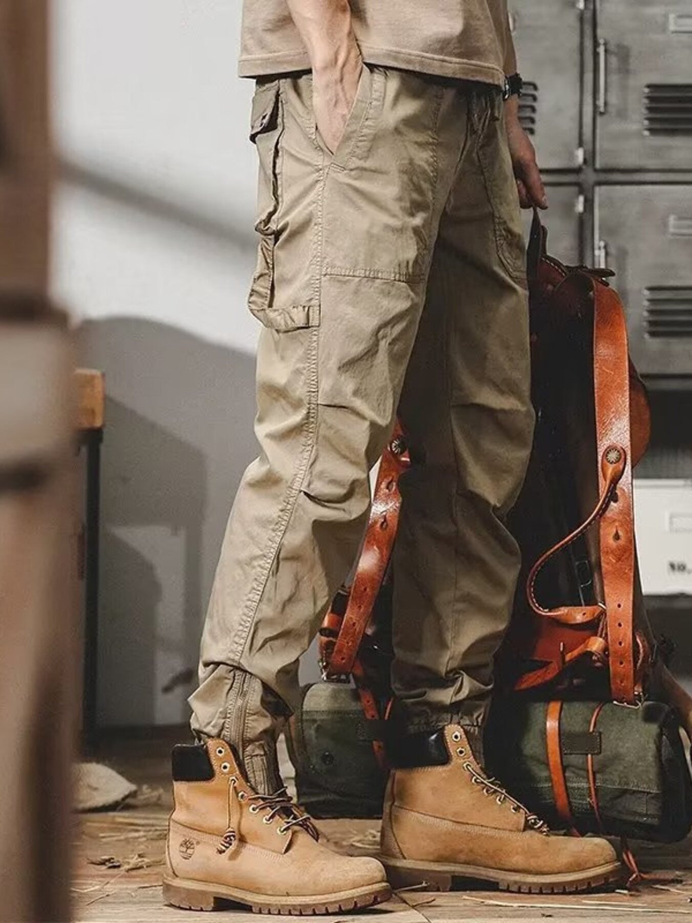 Men's khaki cargo jogger pants with multiple pockets and zippered ankles.