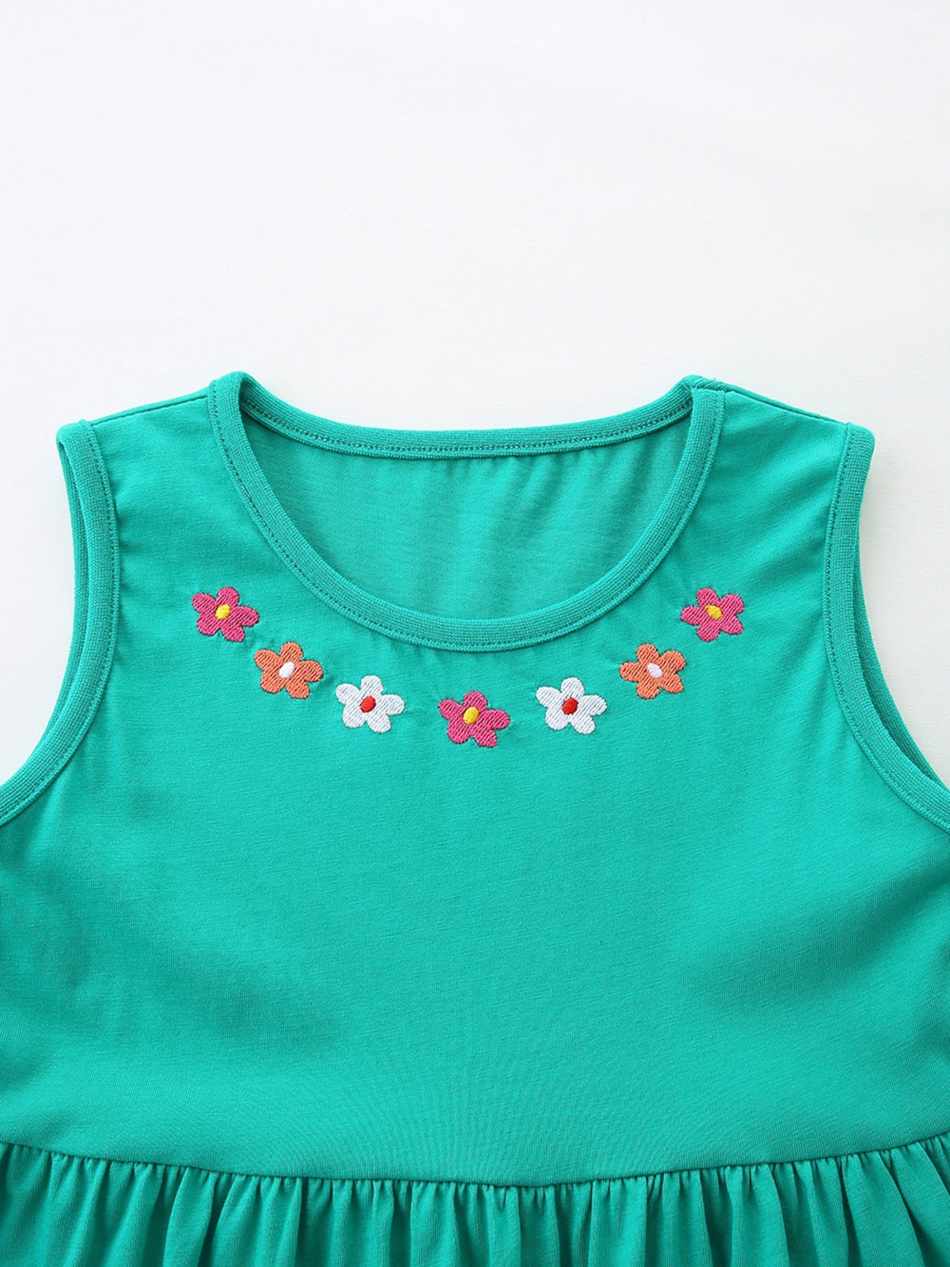 Teal sleeveless A-line dress for kids with embroidered flowers around the neckline.
