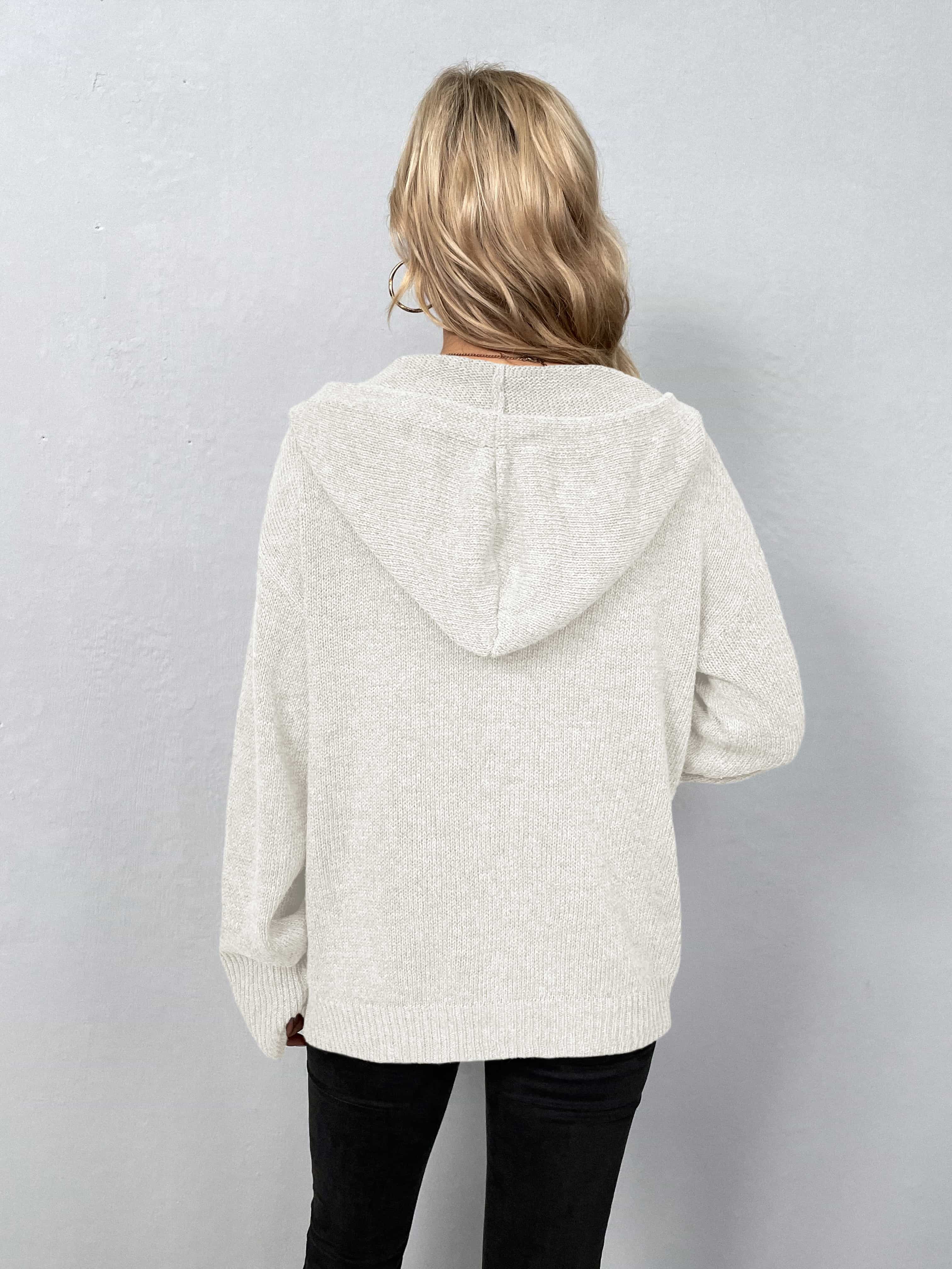 White hooded knit cardigan with button front and ribbed cuffs.