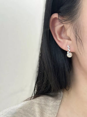 Elegant sterling silver drop earrings with ivory pearl and zircon accents.