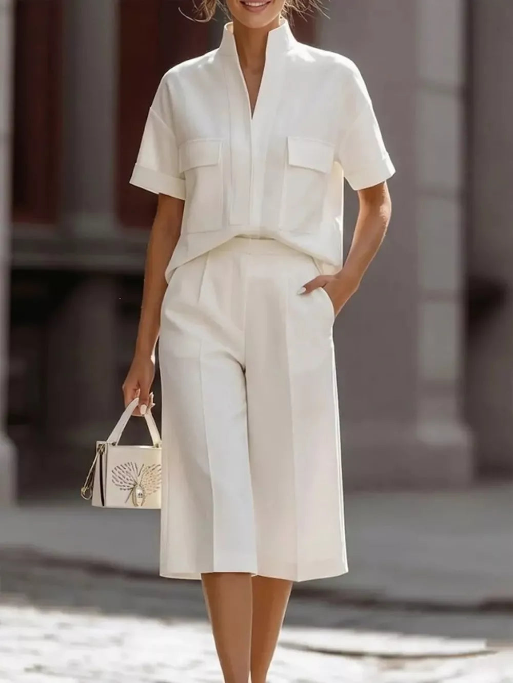 Chic white two-piece set with pocketed short sleeve top and wide leg cropped pants.