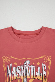 Burnt coral t-shirt with distressed Nashville graphic and guitar neck detail.