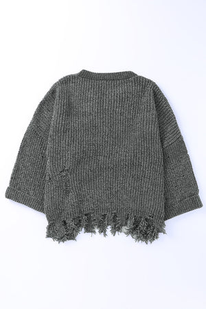 Distressed knit sweater in dark gray with frayed hem and distressed details.