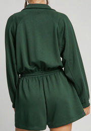 Dark green drawstring waist romper with funnel neck and long sleeves.