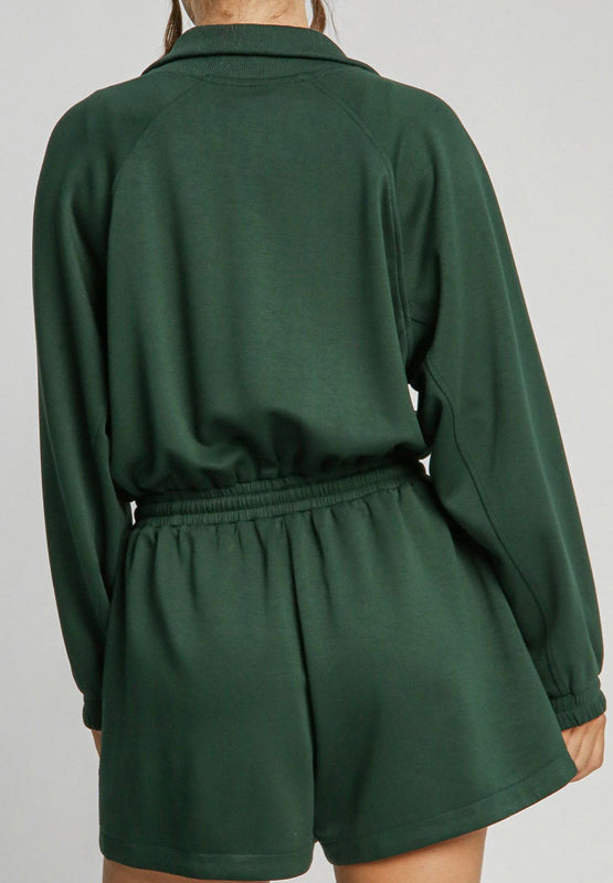 Dark green drawstring waist romper with funnel neck and long sleeves.