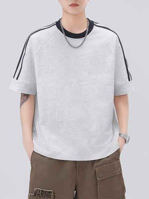 Light gray oversized casual t-shirt with black contrast stitching stripes on raglan sleeves.