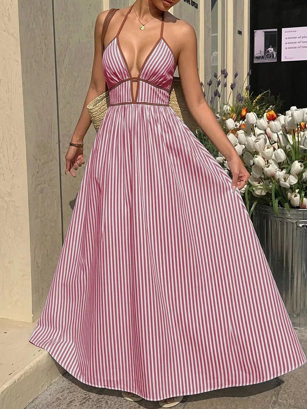 Burgundy striped halter maxi dress with plunging neckline and a-line skirt.