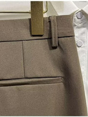 Men's brown chino shorts detail view, showing waistband, belt loop, and pocket.