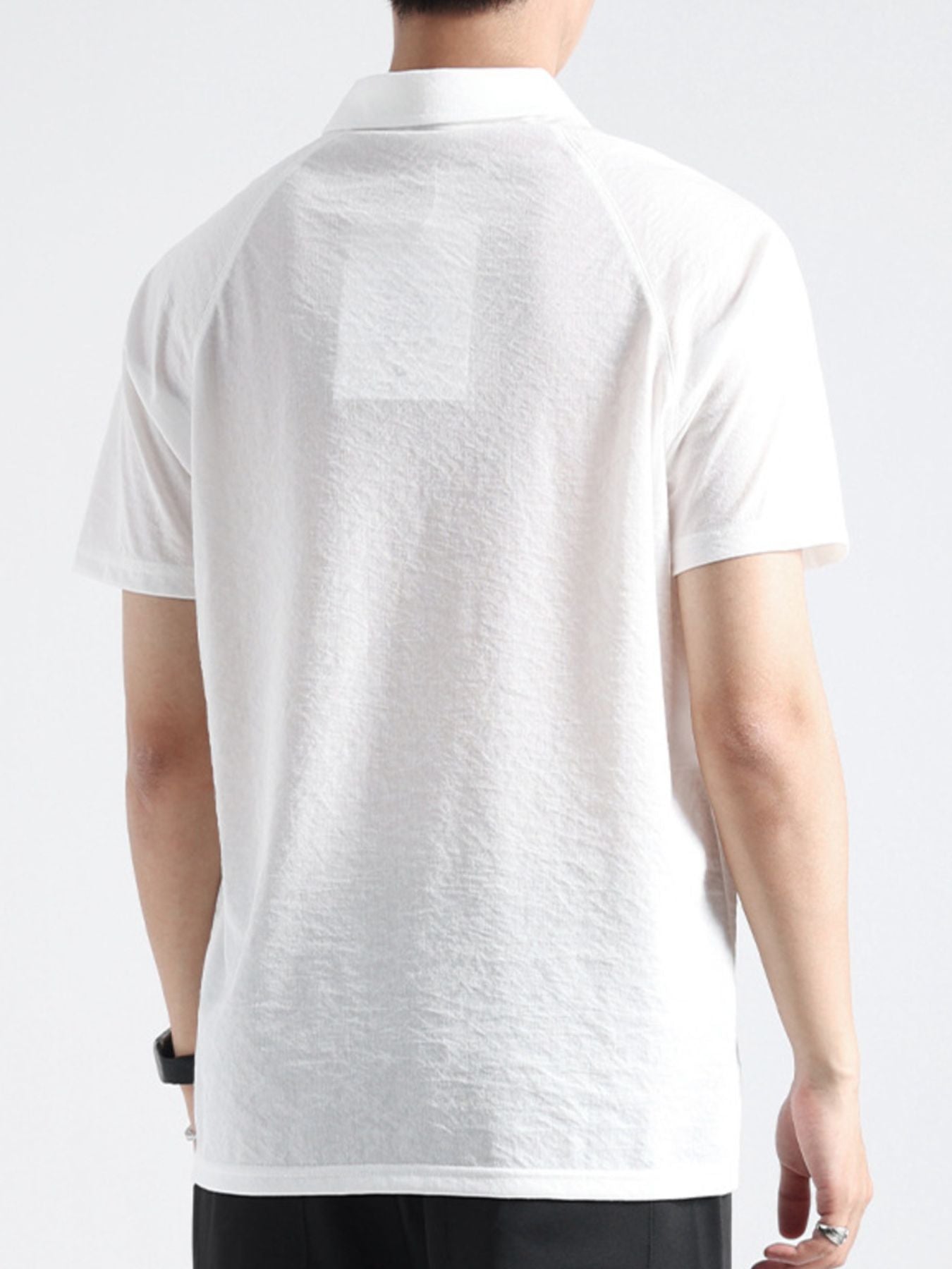 White cotton blend polo shirt with short sleeves and a classic collar, shown from the back.