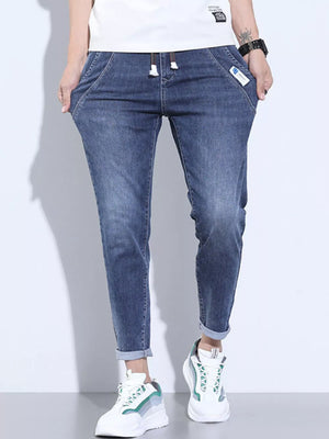 Washed skinny jeans in dark blue with adjustable drawstring and cuffed ankles.