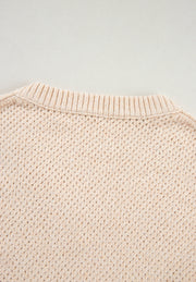 Beige open-knit V-neck sweater with ribbed neckline and textured stitch detail.