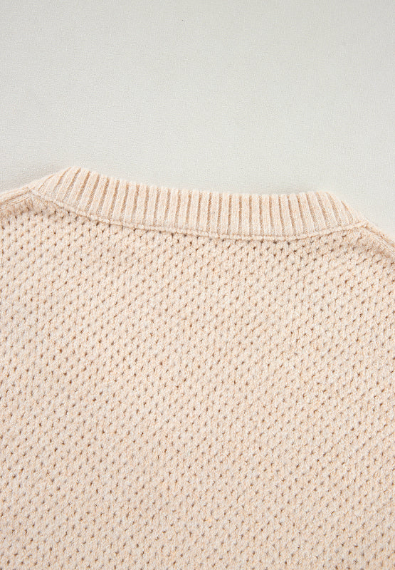 Beige open-knit V-neck sweater with ribbed neckline and textured stitch detail.