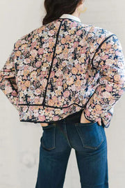 Floral quilted jacket with contrast piping and a dark floral print.
