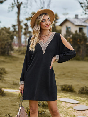 Black cold shoulder mini dress with lace trim neckline and cuffs.