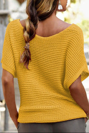 Open-knit dolman sleeve top in gold with a boat neckline and textured acrylic knit.
