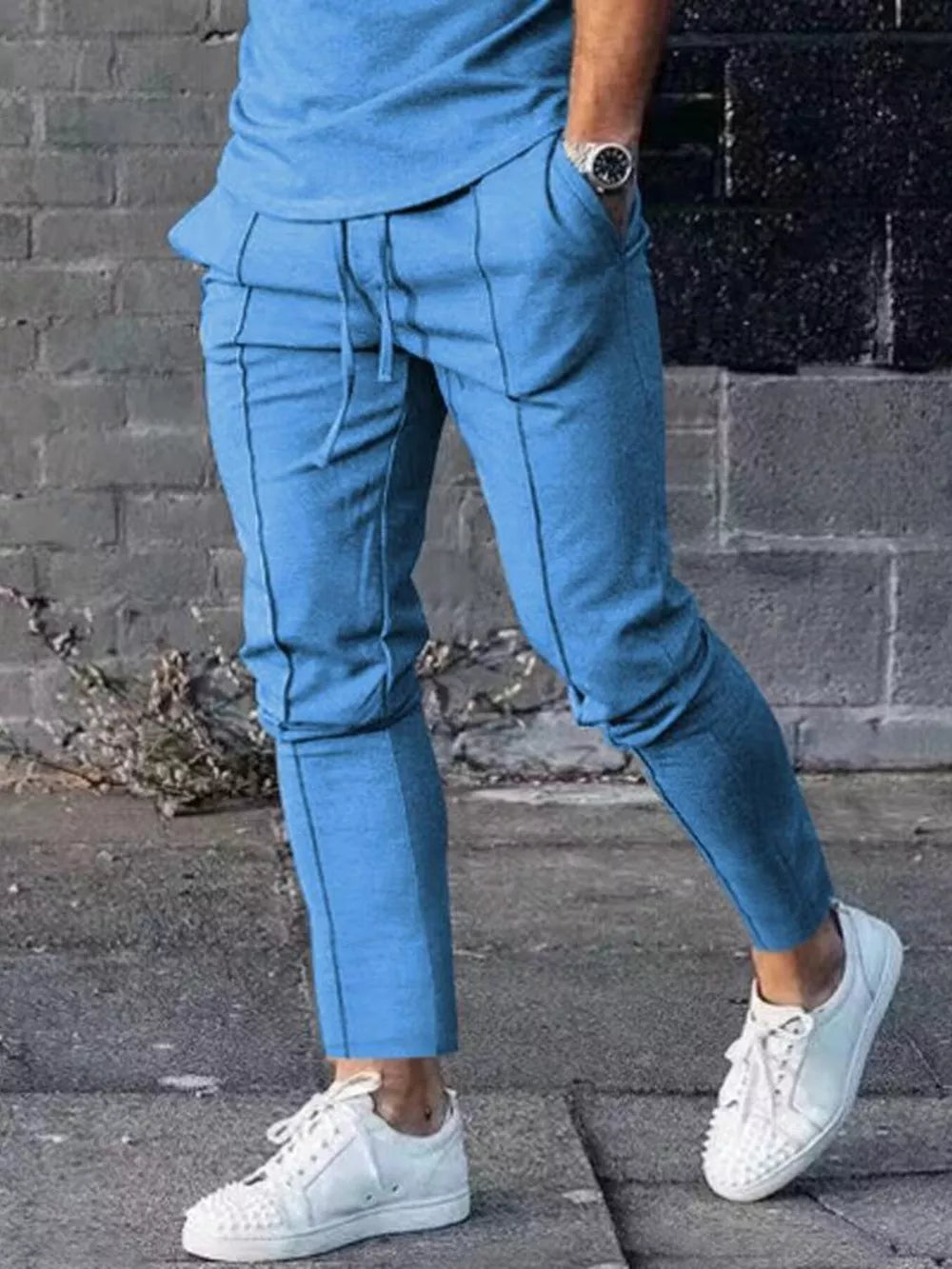 Light blue casual drawstring sweatpants with pockets and contrast stitching.
