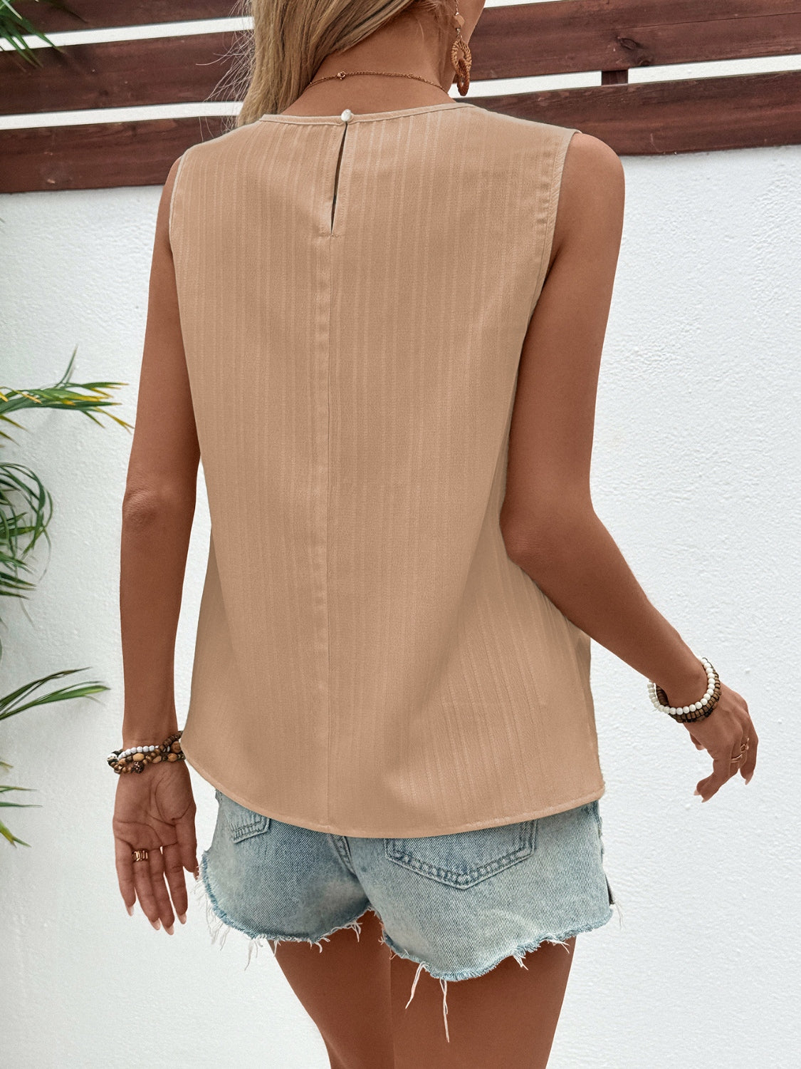 Camel sleeveless blouse with subtle vertical texture and keyhole back detail.