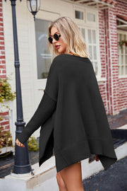 Black acrylic sweater with asymmetric hemline, ribbed sleeves, and side slits.