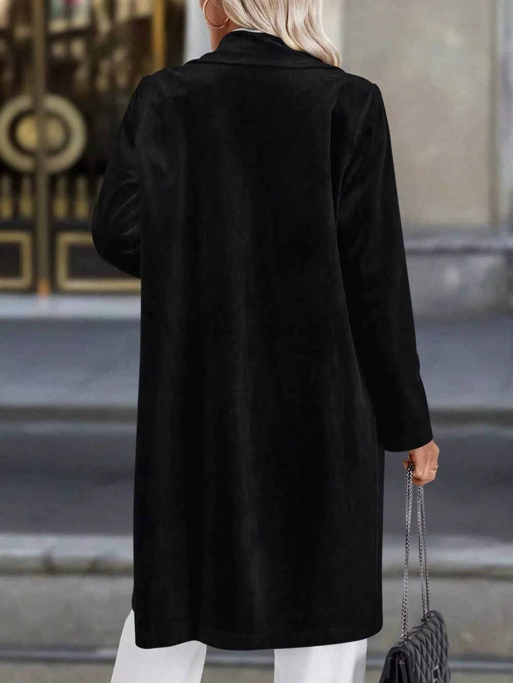 Black longline trench coat with lapel collar, buttoned front, and long sleeves.