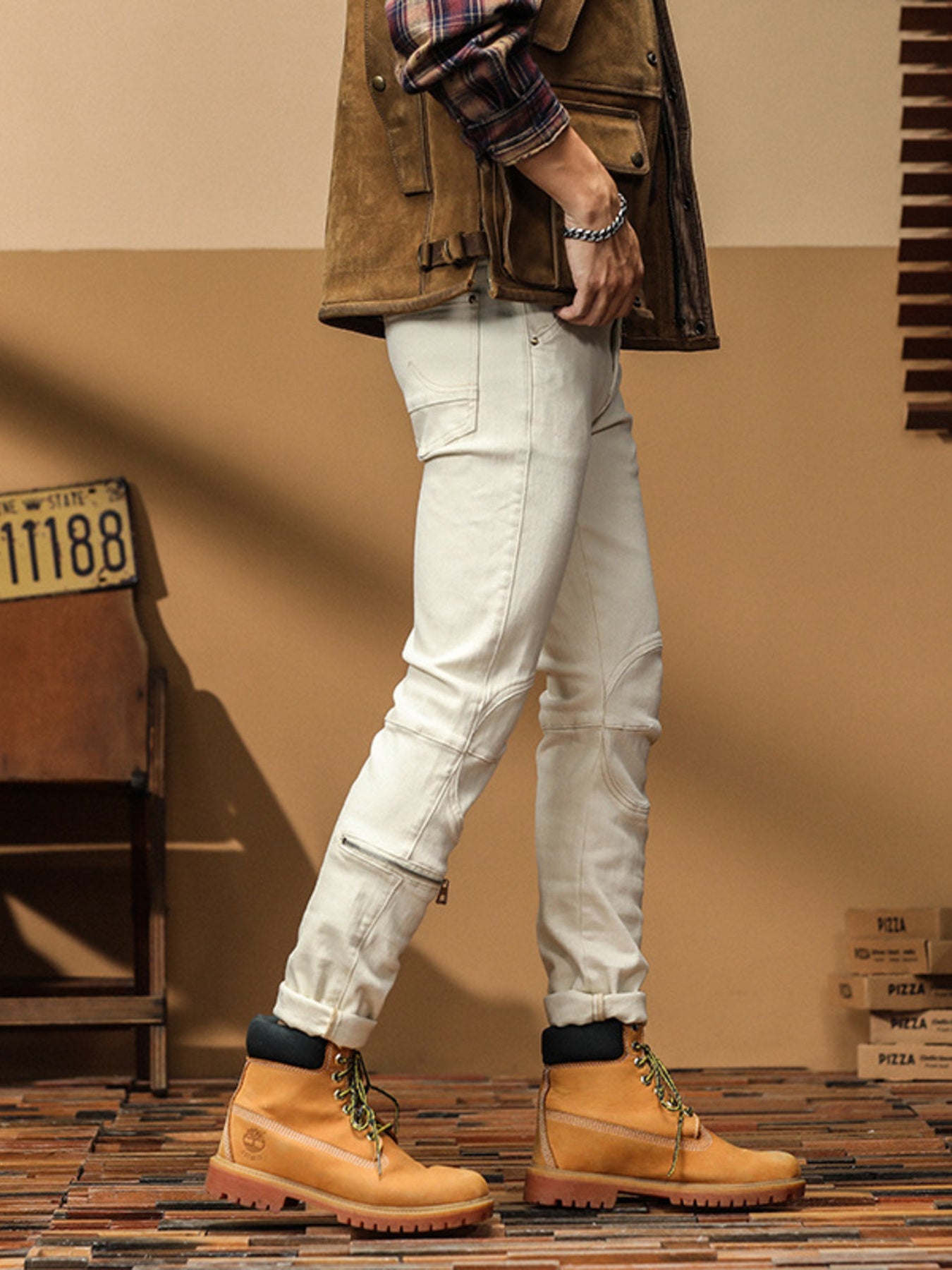 Men's light wash denim jeans with zip ankle detail and moto-style stitching.