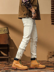 Men's light wash denim jeans with zip ankle detail and moto-style stitching.