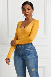 Gold long sleeve bodysuit with plunge neckline and front zipper detail.