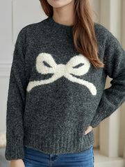 Dark gray acrylic knit sweater with a white intarsia bow design on the front.
