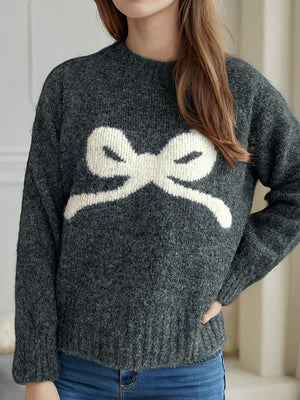 Dark gray acrylic knit sweater with a white intarsia bow design on the front.