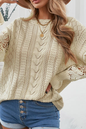 Beige openwork knit sweater with lace sleeves and cable knit details.