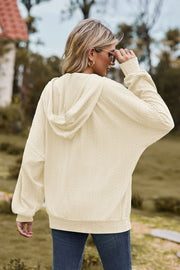 Ivory textured cable knit hoodie with a zip-up front and hood.