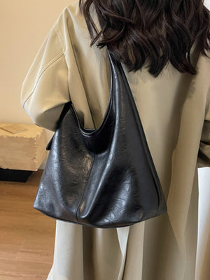 Black faux leather shoulder bag with a slouchy, oversized design.