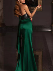 Green satin evening gown with asymmetrical sequin bodice and draped detail.