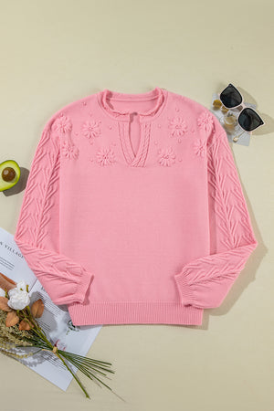 Pink knit sweater with embroidered floral details and notch neck.