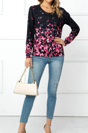 Black crewneck cardigan with pink butterfly print and button front, styled with jeans.