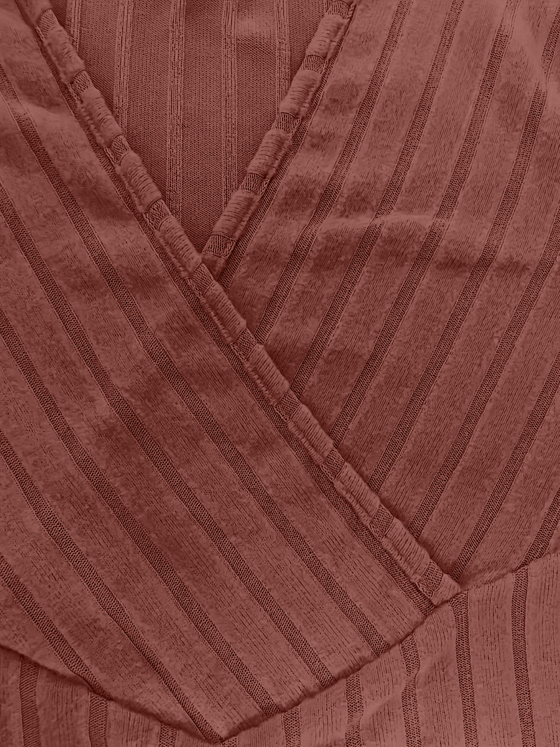 Ribbed wrap top in rust with a plunging neckline and vertical stripe texture.