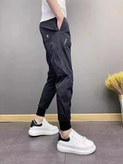 Black cotton sweatpants with ankle cuffs and zippered pocket detail.