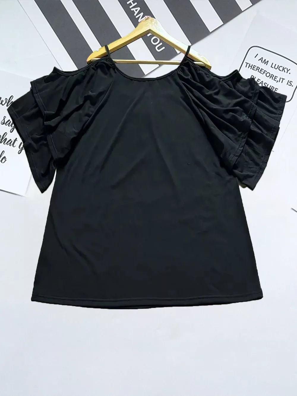Black t-shirt with gathered neckline and ruffled cold-shoulder sleeves.