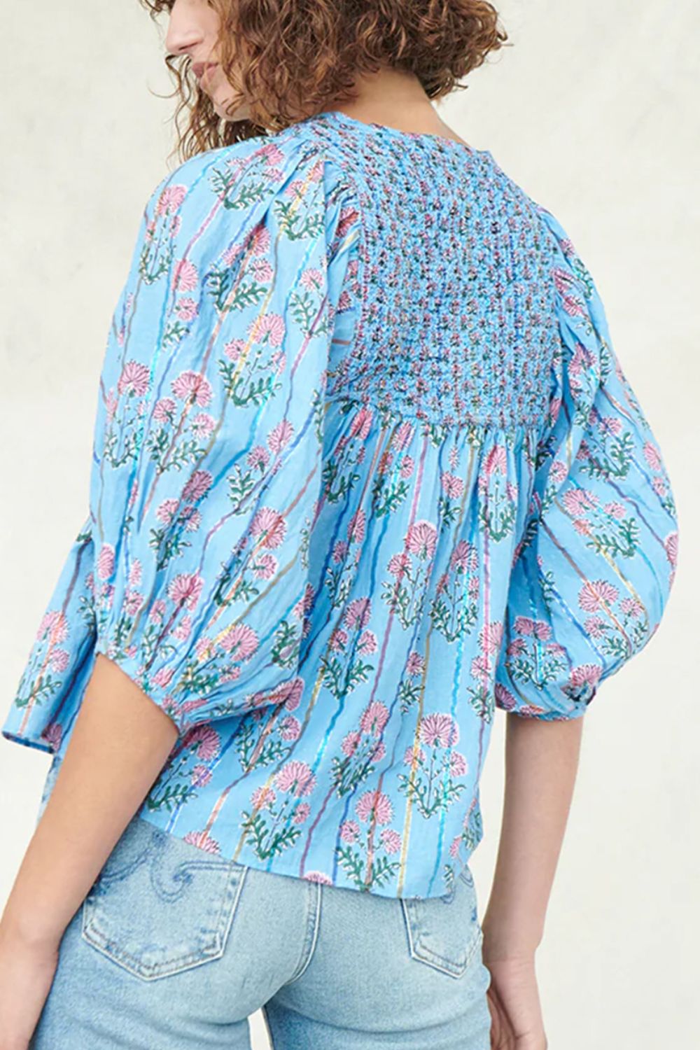 Sky blue floral print smocked yoke blouse with puff sleeves and striped pattern.