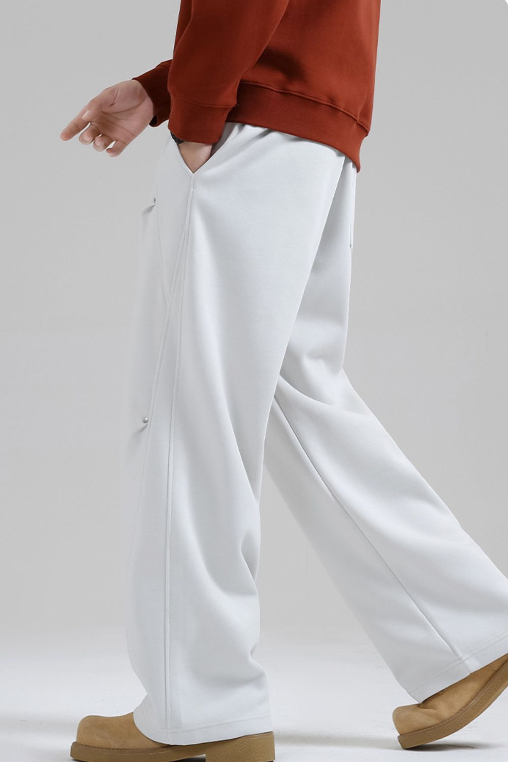 Men's light grey drawstring sweatpants with side snap detail and pockets.