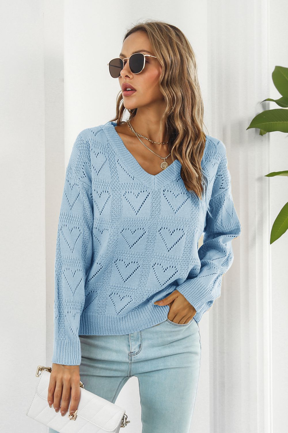 Light blue acrylic V-neck sweater with allover heart stitch pattern.