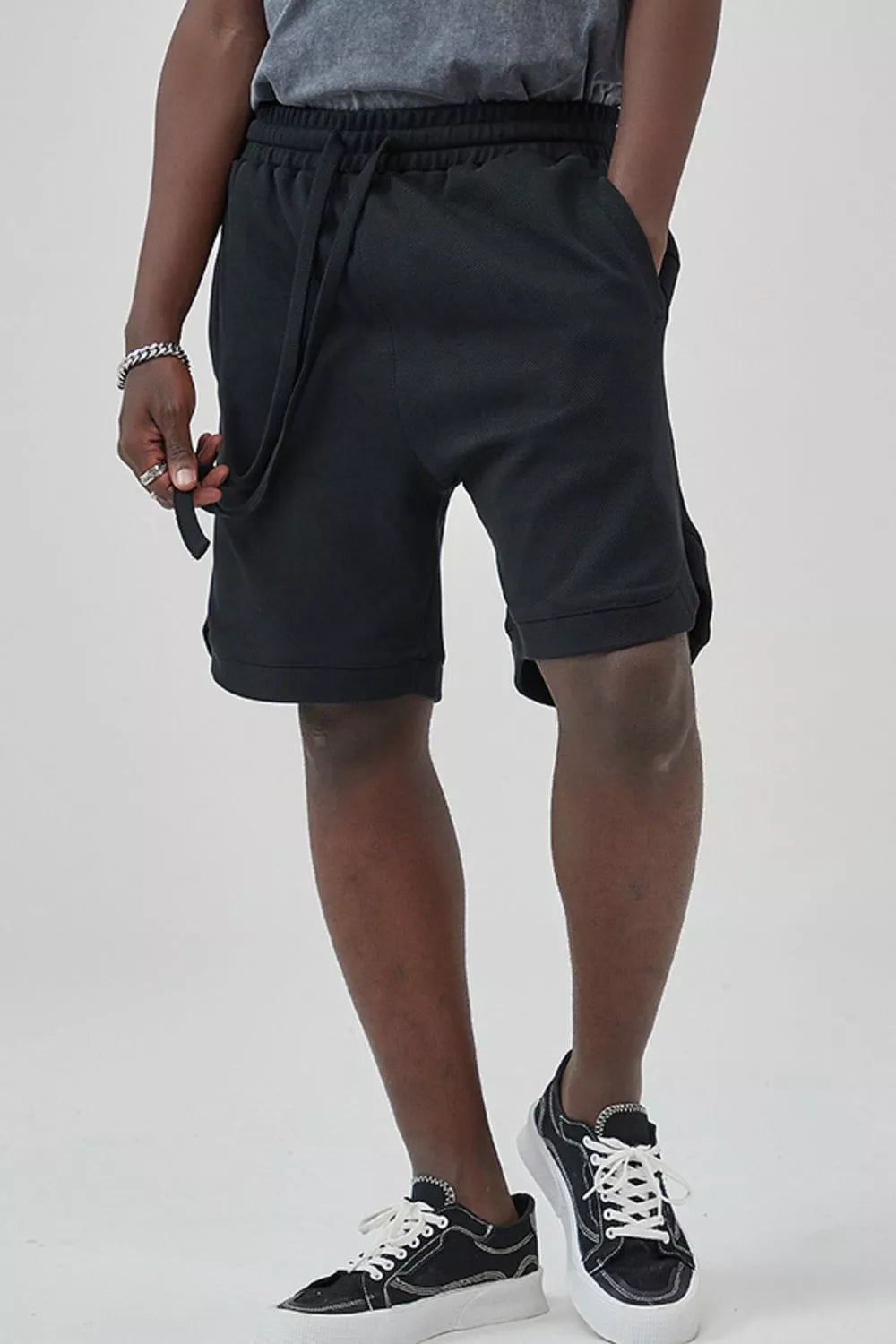 Men's black drawstring boxer shorts with pockets and a relaxed fit.